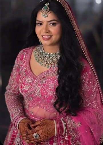 Pink lehenga bride with open curls and emerald jewellery — Barbie bride look