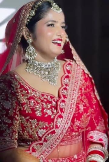 Smiling bride in red lehenga with silver kundan necklace
